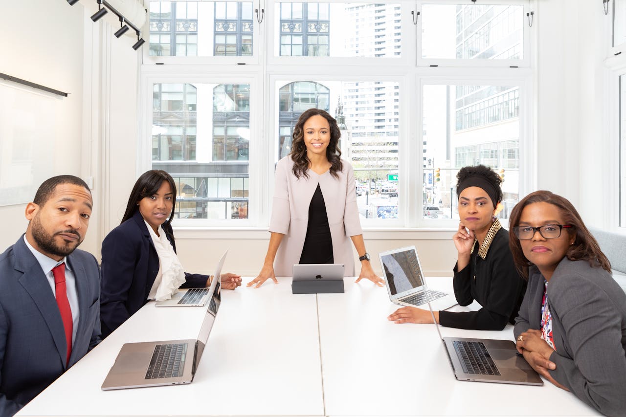 Professional team collaborating in a bright, modern conference room with laptops.